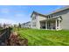 Well-maintained backyard featuring a covered patio, a lush lawn, and a sleek black fence, perfect for outdoor enjoyment at 15813 Arthur Jacob Ln, Noblesville, IN 46060