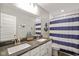Charming bathroom with double sink vanity, nautical decor, and blue striped shower curtain at 15813 Arthur Jacob Ln, Noblesville, IN 46060