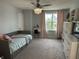 Bright bedroom features a daybed, vanity, ceiling fan with light, and large window at 15813 Arthur Jacob Ln, Noblesville, IN 46060