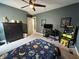Bedroom with galaxy-themed bed, ceiling fan, and desk area, featuring an arcade game at 15813 Arthur Jacob Ln, Noblesville, IN 46060