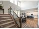 Open-concept living space features a dining area adjacent to a modern kitchen and a staircase with metal balusters at 15813 Arthur Jacob Ln, Noblesville, IN 46060