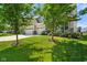 Landscaped front yard with young trees, leading to a charming two-story home with a three-car garage at 15813 Arthur Jacob Ln, Noblesville, IN 46060