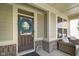 Charming front porch with a wreath-adorned door and cozy wicker chairs at 15813 Arthur Jacob Ln, Noblesville, IN 46060