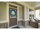 Cozy front porch featuring brick accents, a wreath on the door, and comfortable seating area at 15813 Arthur Jacob Ln, Noblesville, IN 46060
