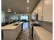 Bright kitchen boasts an island, pendant lighting, white cabinets, stainless appliances, and an open view to the living room at 15813 Arthur Jacob Ln, Noblesville, IN 46060