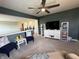 Bright living room with TV, shelving, and blue accent chairs on a carpeted floor at 15813 Arthur Jacob Ln, Noblesville, IN 46060