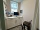 Cozy office nook with built-in desk, storage cabinets, quartz countertops, and natural light from a window at 15813 Arthur Jacob Ln, Noblesville, IN 46060