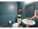 Stylish powder room features a unique paint color, modern fixtures, and a sleek pedestal sink for guests at 15813 Arthur Jacob Ln, Noblesville, IN 46060