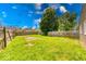 Large backyard with grass and a wood fence and blue skies with clouds at 1641 Deloss St, Indianapolis, IN 46201