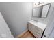 Bathroom featuring single sink vanity, a framed mirror, wood floors, and soft gray walls at 1641 Deloss St, Indianapolis, IN 46201