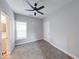 Bedroom features carpeted floors, a ceiling fan, and a glimpse of a well-lit bathroom at 1641 Deloss St, Indianapolis, IN 46201
