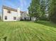 Large, green backyard with a spacious lawn, patio, and privacy from mature trees at 1680 Woodfield Dr, Greenwood, IN 46143