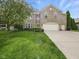Lovely two-story brick home boasting a spacious front lawn and three-car garage at 1680 Woodfield Dr, Greenwood, IN 46143