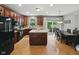 Spacious kitchen with an island and dining area, featuring dark wood cabinets and modern lighting at 1680 Woodfield Dr, Greenwood, IN 46143
