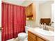 Standard bathroom with red shower curtain, cabinet, toilet, mirror, and sink at 17401 Austrian Pine Way, Westfield, IN 46074