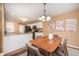 Cozy dining area with a modern table set, hardwood floors, stylish light fixture, and access to the kitchen at 1856 Misty Lake Dr, Indianapolis, IN 46260