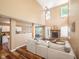 Spacious living room boasting high ceilings, a brick fireplace, hardwood floors, and a comfortable sectional at 1856 Misty Lake Dr, Indianapolis, IN 46260