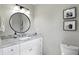 Bright bathroom featuring a round mirror, modern vanity with a stone countertop, and neutral wall color at 1981 N Valley Ln, Greenfield, IN 46140