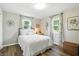 Cozy bedroom with a comfortable bed, two windows with curtains, and hardwood floors at 1981 N Valley Ln, Greenfield, IN 46140