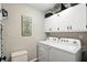 Convenient laundry room with white appliances, upper cabinets, and inspirational decor at 1981 N Valley Ln, Greenfield, IN 46140