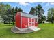 Charming red shed with white trim, nestled in a verdant yard, adding a touch of rustic elegance to the landscape at 1981 N Valley Ln, Greenfield, IN 46140