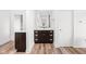 Bathroom showcasing a dark vanity with drawers, an expansive mirror, and wood-look flooring at 20450 Chatham Hills Blvd, Westfield, IN 46074