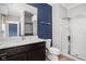 Bathroom featuring a dark wood vanity, a walk in shower, blue accent wall and toilet at 20450 Chatham Hills Blvd, Westfield, IN 46074