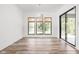 Bright dining room with a sliding glass door, wood floors, and three windows with woven blinds at 20450 Chatham Hills Blvd, Westfield, IN 46074