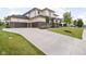 Long concrete driveway leading to a three-car garage, with manicured lawn and landscaping at 20450 Chatham Hills Blvd, Westfield, IN 46074