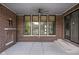 Covered brick patio featuring an outdoor fireplace, ceiling fan, and large windows for natural light at 20450 Chatham Hills Blvd, Westfield, IN 46074