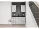 Wet Bar with modern gray cabinets and black countertop, located near the staircase at 20450 Chatham Hills Blvd, Westfield, IN 46074