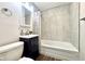 Bathroom featuring a navy vanity with tub and shower and decorative grey tile at 2563 Harlan St, Indianapolis, IN 46203
