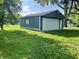 Garage with white door and blue siding set against a lush green yard at 3190 S Tacoma Ave, Indianapolis, IN 46237