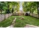 Large, grassy backyard with fire pit, shed, and a wooden fence, perfect for outdoor enjoyment at 3709 Central Ave, Indianapolis, IN 46205