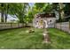 Backyard featuring a fire pit, lush green lawn, and a privacy fence surrounding the property at 3709 Central Ave, Indianapolis, IN 46205