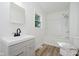 Bright bathroom with a modern vanity, white shower-tub combo and light wood-look floors at 3709 Central Ave, Indianapolis, IN 46205