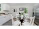 Bright eat-in kitchen featuring stainless steel appliances, white cabinets, and a glass table at 3709 Central Ave, Indianapolis, IN 46205