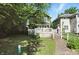 A backyard with lush greenery with a deck, brick steps and the house beyond at 39 N Bosart N Ave, Indianapolis, IN 46201