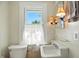 Cozy bathroom features a pedestal sink, toilet, and a bright window at 39 N Bosart N Ave, Indianapolis, IN 46201