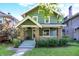 Charming two-story home featuring a cozy front porch with brick accents and lush landscaping at 39 N Bosart N Ave, Indianapolis, IN 46201