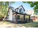 Beautiful two-story home with a covered porch, a manicured lawn, and stylish black accents at 402 N Oxford St, Indianapolis, IN 46201