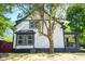 Side view of home showcasing white siding, black trim, bay windows, and covered porch at 402 N Oxford St, Indianapolis, IN 46201