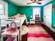 Bright bedroom features a playful loft bed, ceiling fan, and bright teal walls at 430 W Locust St, Shelbyville, IN 46176