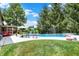 Green lawn and pool area, complete with lounge furniture, sun umbrellas, and lush landscaping, provide an ideal space for relaxation at 4704 Pearcrest Way, Greenwood, IN 46143