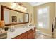 Bright bathroom featuring a large mirror, vanity with sink, and a window with shutters at 4704 Pearcrest Way, Greenwood, IN 46143