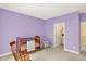 Bedroom room with purple walls, a baby's crib, a rocking chair, and a door to a walk-in closet at 4704 Pearcrest Way, Greenwood, IN 46143