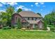 Beautiful brick home with manicured lawn, mature trees, and lush landscaping at 4704 Pearcrest Way, Greenwood, IN 46143