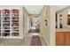 Bright hallway with a view to the front door, featuring carpet, a built-in bookcase, and light neutral walls at 4704 Pearcrest Way, Greenwood, IN 46143