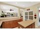 Open concept kitchen with island and pass through, featuring warm wood cabinets, light countertops, and ample storage space at 4704 Pearcrest Way, Greenwood, IN 46143