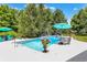 Relaxing backyard pool area with lounge chairs, patio umbrellas and decorative greenery perfect for outdoor entertaining and relaxation at 4704 Pearcrest Way, Greenwood, IN 46143